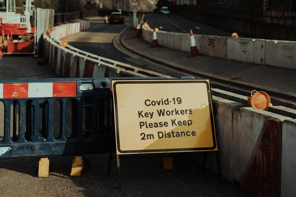 Covid 19パンデミックの間の沿道建設労働者のための物理的な距離警告サイン — ストック写真