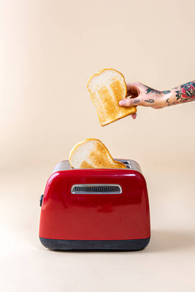 Hand Holding Bread Popping Red Toaster — Stock Photo, Image