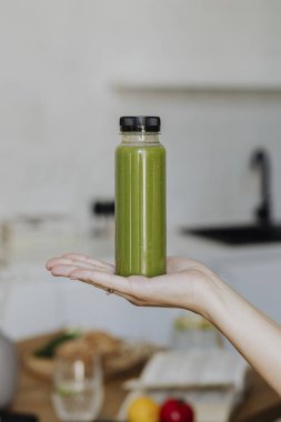 Elinde bir şişe kereviz suyu tutan kadın.