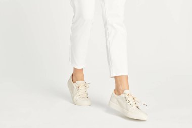 Beyaz spor ayakkabı giyen kadın modeli.