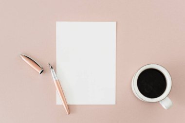 Kalem kâğıdı ve kahve masanın üstünde.