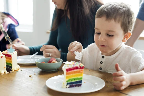 Kleine Jongen Etend Een Regenboog Kleurig Koek — Stockfoto