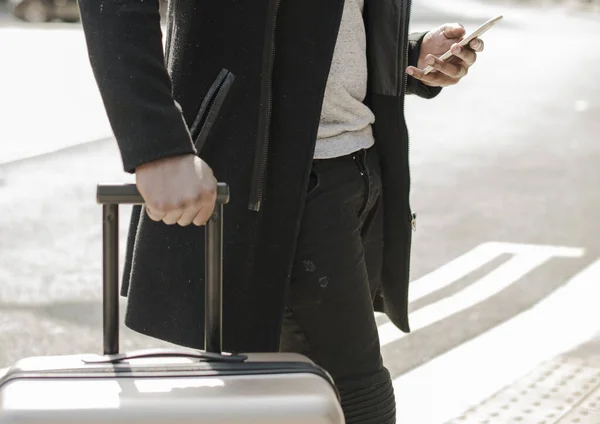 Tourist Mit Koffer Blickt Auf Sein Handy — Stockfoto