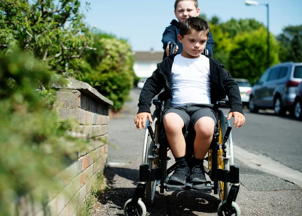 Boy Pushing His Brother Wheelchair — Stock Photo, Image