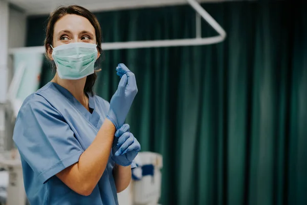 Enfermeira Feminina Com Uma Máscara Colocando Luvas — Fotografia de Stock
