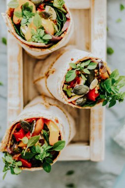 Tortilla kızarmış sebze ve mozzarella peynirli yemek fotoğrafçılığıyla sarılır.