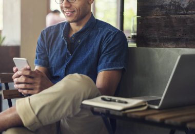 Telefonuyla oynayan bir adam.