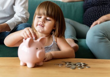 Family saving money in piggy ban