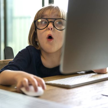 Gözlüklü genç kız bilgisayar kullanmaktan şok oldu.