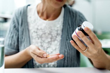 Kadın ilaçlarını yakın plan çekiyor.