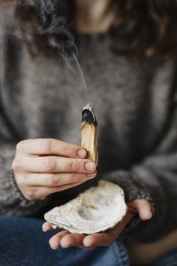 Palo Santo 'yu evini temizlediği için yakan kadın.