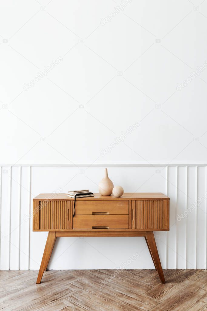 Wooden sideboard table with books and a vase