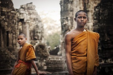 Monks near ruins in Cambodia clipart