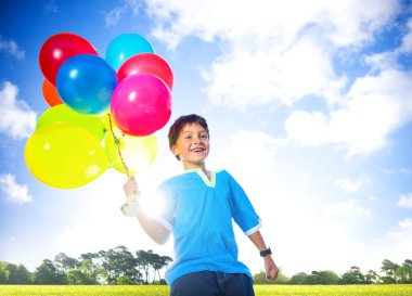 Çocuk açık havada helyum balonlar ile