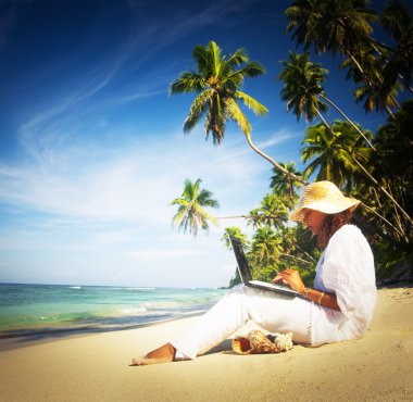 laptop sahilde bir kadınla.