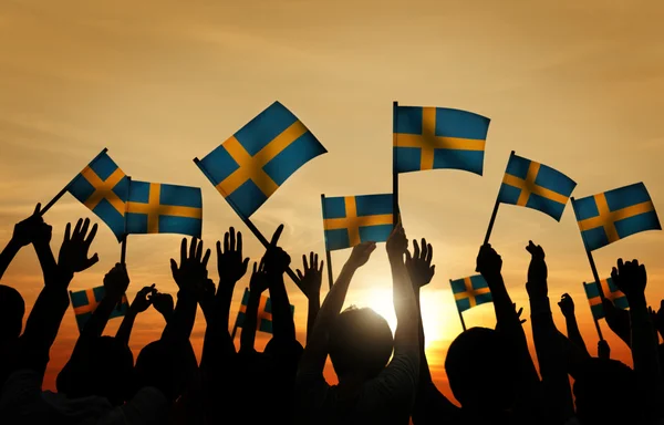Люди размахивают шведскими флагами — стоковое фото