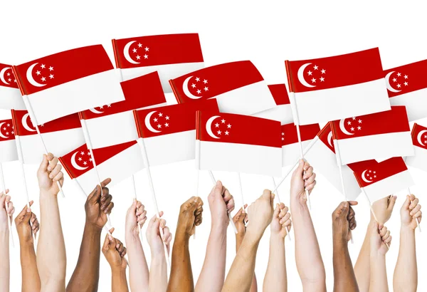 Руки с флагами Сингапура — стоковое фото