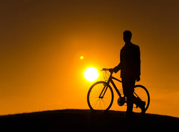 Zakenman wandelen met de fiets langs de heuvel — Stockfoto