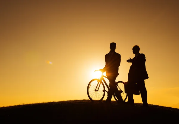 Businessmen walking with bicycle along the hill — Stock Photo, Image