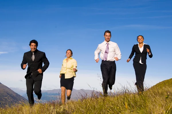 Uomini d'affari che corrono sulle montagne — Foto Stock