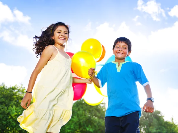 Menina e menino com balões — Fotografia de Stock