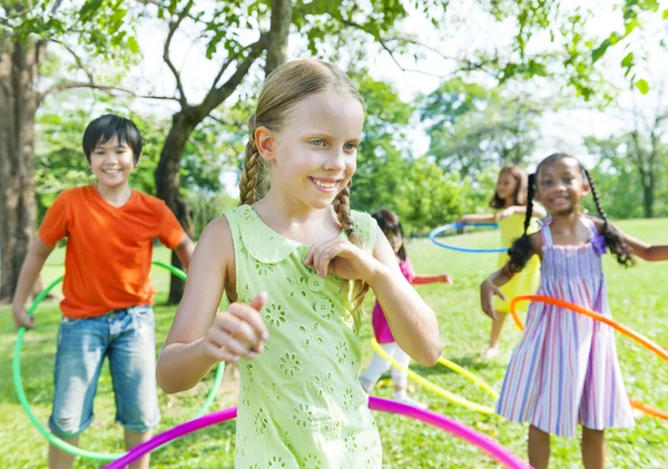 Дети играют с обручами в парке — стоковое фото