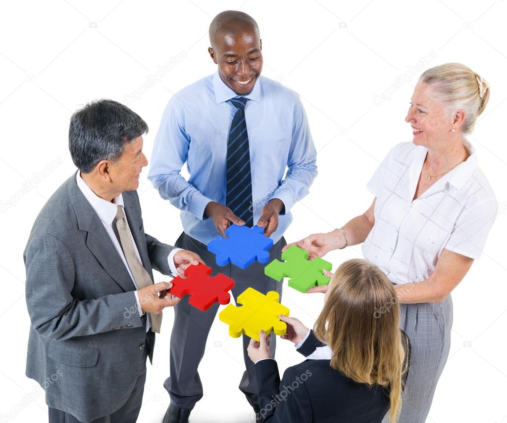 Business people building jigsaw