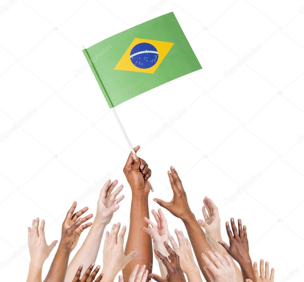 Human hand holding Brazil Flag