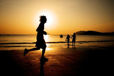 gün batımında sahilde koşu adam