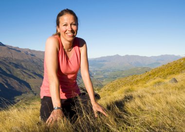 gülümseyen kadın kayalıklarda oturan