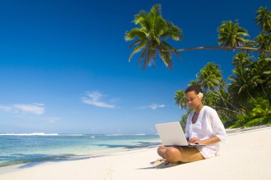 laptop sahilde bir kadınla