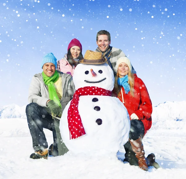 Amigos posando con muñeco de nieve —  Fotos de Stock