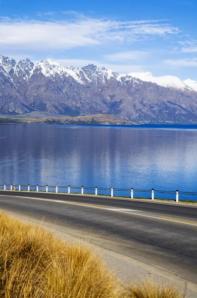 Route avec lac et chaîne de montagnes — Photo