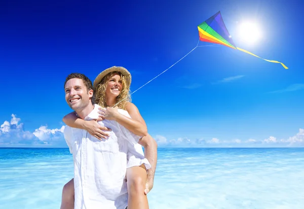 Paar lässt Drachen am Strand steigen — Stockfoto