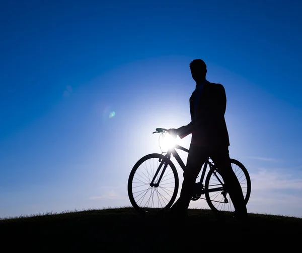 Businessman walking with bicycle along the hill — Stock Photo, Image