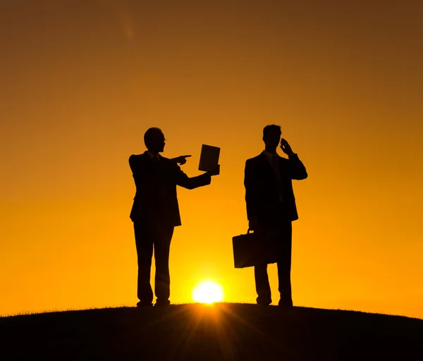 Businessmen using tablet and smartphone on the hill — Stock Photo, Image