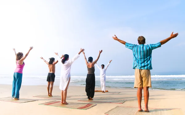 Yoga klas door strand — Stockfoto