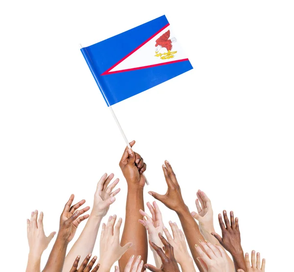 Mano humana sosteniendo bandera de Samoa Americana —  Fotos de Stock