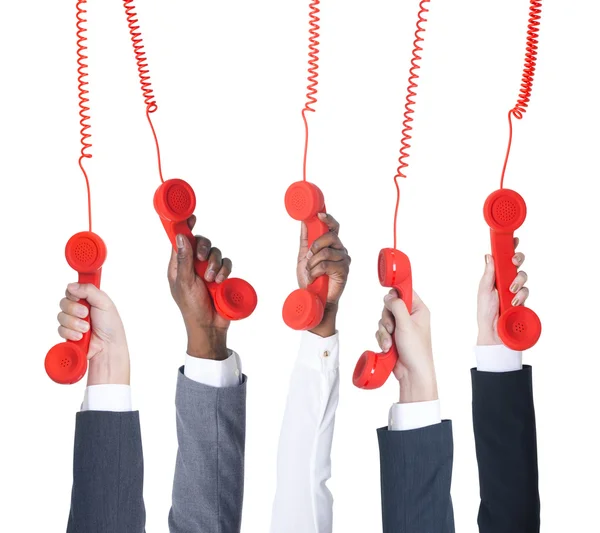 Negócios segurando telefones vermelhos — Fotografia de Stock