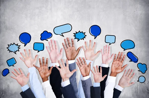 Business arms raised with speech bubbles — Stock Photo, Image