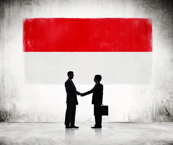 Biznesmenów drżenie rąk z flagą Indonezji — Zdjęcie stockowe