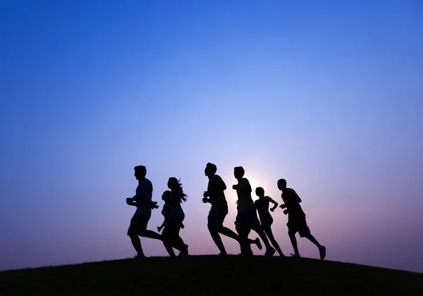 Pessoas a correr ao pôr-do-sol azul — Fotografia de Stock