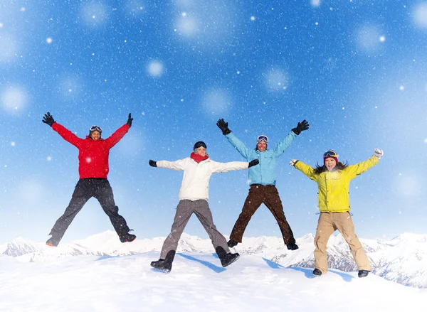 Pessoas felizes pulando na neve — Fotografia de Stock