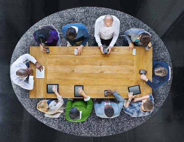 Grupo de pessoas em uma tabela usando dispositivos — Fotografia de Stock