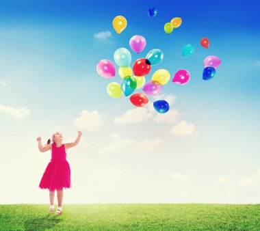 Küçük kız balonlarla oynuyor.