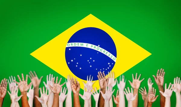 Mãos multi-étnicas com bandeira do Brasil — Fotografia de Stock