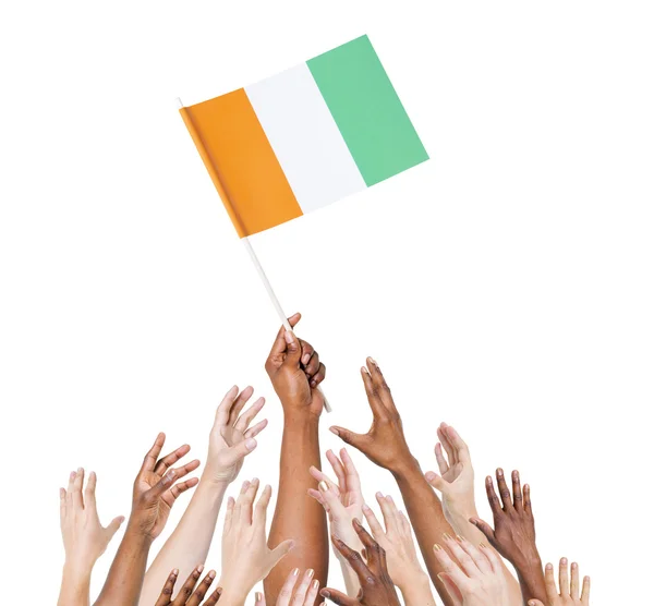 Menschen greifen nach der Flagge der Elfenbeinküste — Stockfoto