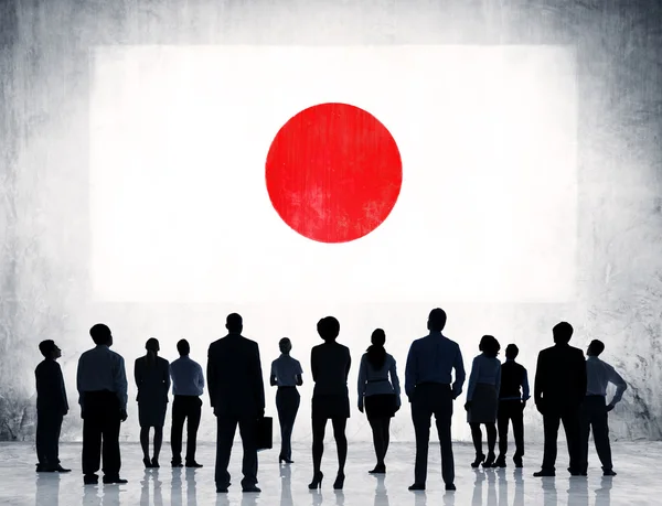 Деловые люди с флагом Японии — стоковое фото