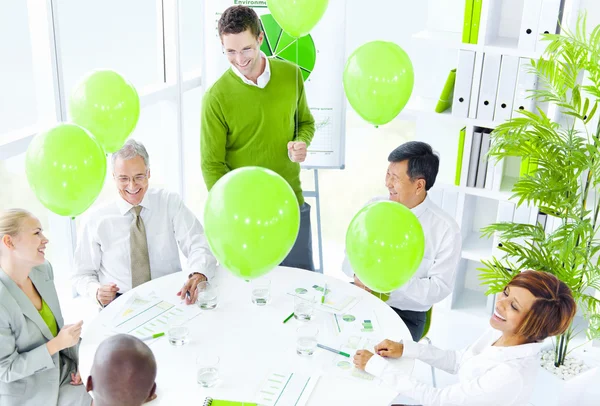 Business people with green balloons — Stock Photo, Image