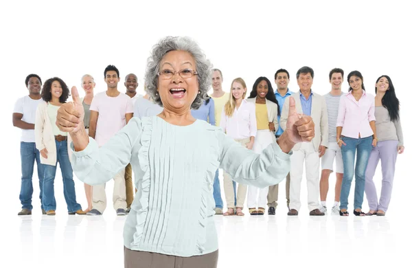 Senior woman standing out from crowd — Stock Photo, Image